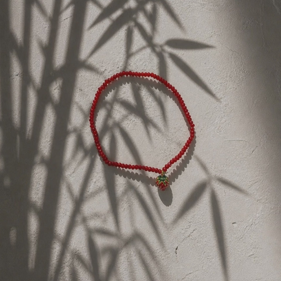 rotes Perlenarmband mit Anhänger